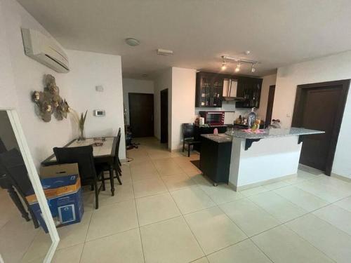 uma cozinha e sala de estar com um balcão e uma mesa em Beautiful 2 Bedrooms Apartment - Azaiba em ‘Udhaybah