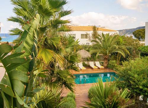 a resort with a swimming pool and palm trees at Es Caló Luxe - Formentera Break in Es Calo