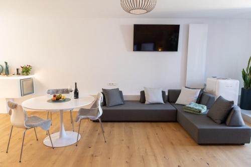 a living room with a couch and a table at geislerAPPARTMENTS in Gramatneusiedl