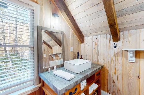 a bathroom with a sink and a mirror at Etowah River Escape in Dahlonega
