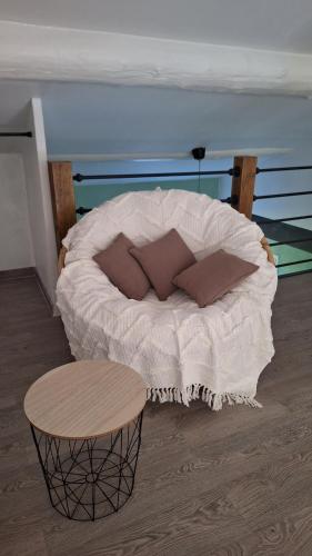 a bed with pillows and a table in a room at Loft en duplex au Mas de la Restanque in Monteux