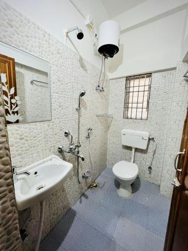 a bathroom with a toilet and a sink at Queen's Residency in Guwahati