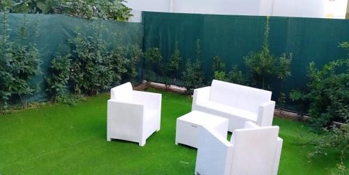 two white chairs sitting on the grass in a backyard at Villa Levante in Barletta