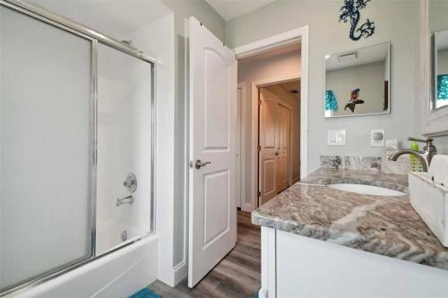 a white bathroom with a sink and a shower at 3bed3bath Waterfront Home with an Amazing View! in Hernando Beach
