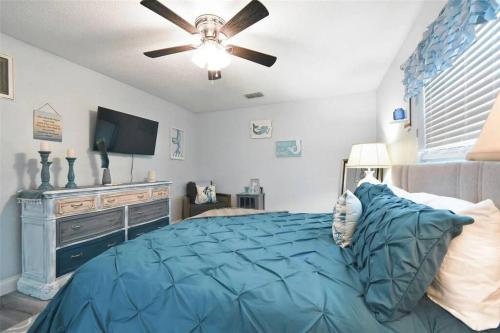 a bedroom with a blue bed and a ceiling fan at 3bed3bath Waterfront Home with an Amazing View! in Hernando Beach