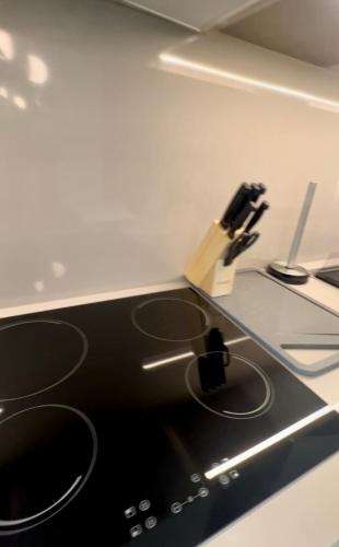 a black stove top oven with a knife on a counter at شقق فندقية خاصة في منتجع العنوان الشاطئي - مراسي البحرين in Rayyā
