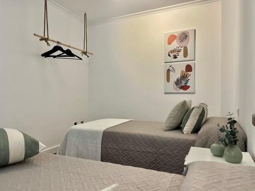 2 camas en una habitación blanca con 2 camas en Nuevo Piso en Couto, en Ourense