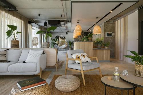 ein Wohnzimmer mit einem Sofa, Stühlen und Tischen in der Unterkunft Saltic Resort & Spa Łeba in Łeba