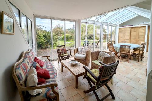 a living room filled with furniture and a table at Rare pearl with garden facing the sea in Saint-Coulomb
