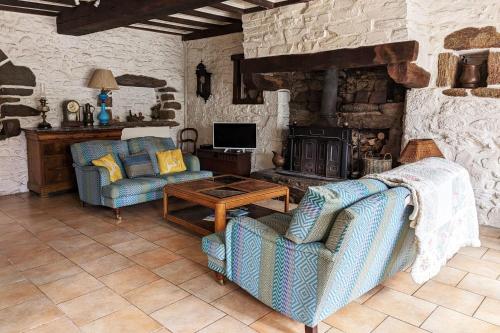 a living room with two chairs and a fireplace at Rare pearl with garden facing the sea in Saint-Coulomb