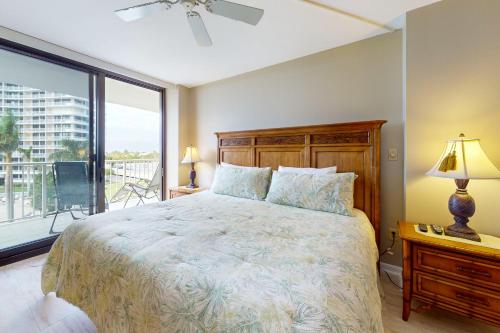 a bedroom with a large bed and a balcony at Crystal Waves in Marco Island