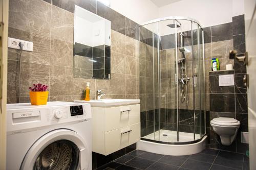 een badkamer met een wasmachine en een douche bij Q Elegance Palas Mall in Iaşi