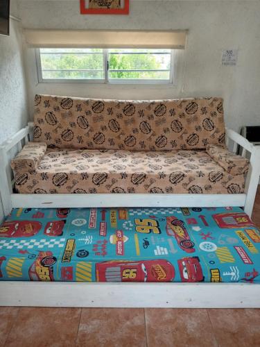 a bed in a tiny house with a blanket on it at Casa de Alquiler 1 in Tanti