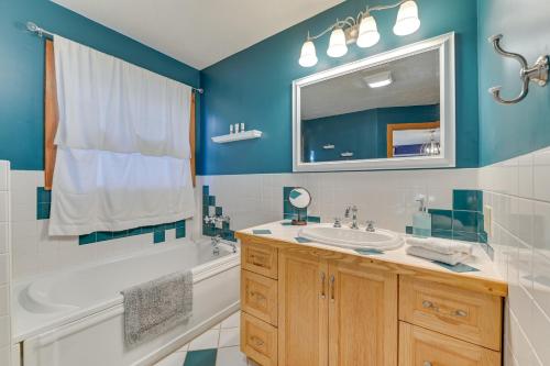 Un baño con bañera, lavabo y espejo. en Slope Views Luxe Windham Retreat with Hot Tub!, en Windham