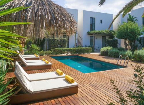 einen Hinterhof mit einem Pool und einer Holzterrasse in der Unterkunft Es Caló Luxe - Formentera Break in Es Caló