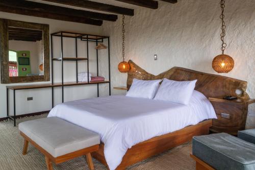 1 dormitorio con 1 cama grande y cabecero de madera en El Edén Country hotel y Club Residencial, en Armenia