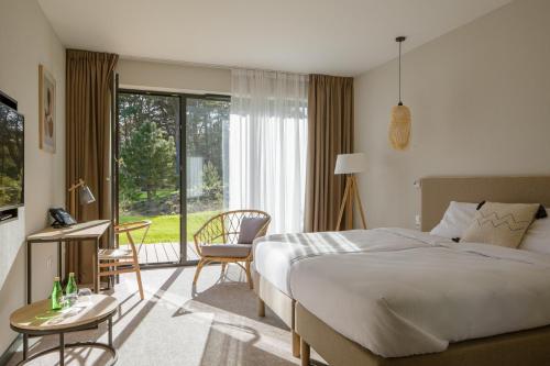 a hotel room with a bed and a large window at Saltic Resort & Spa Łeba in Łeba