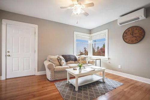 a living room with a couch and a clock on the wall at Walk to the waterfront! The Cozy Cottage in Tacoma