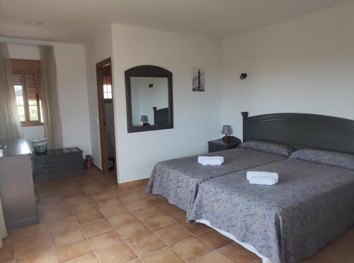 1 dormitorio con 2 camas y espejo en la pared en Vistas al faro, en Cádiz