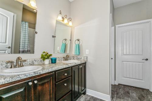a bathroom with two sinks and a mirror at Lovely Townhome in Pensacola - Cozy & Modern Retreat in Pensacola