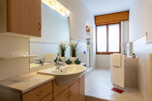 a white bathroom with a sink and a mirror at Il Terrazzino 51 in Bellagio