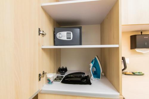 a room with a shelf with a microwave and a tv at LUX Апартаменти MYFREEDOM поруч метро Театральна, Хрещатик in Kyiv