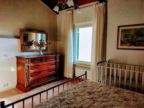 um quarto com uma cama, uma cómoda e um espelho em Casa di Campagna em Ronciglione
