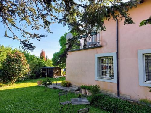 uma casa cor-de-rosa com um banco no quintal em Casa di Campagna em Ronciglione