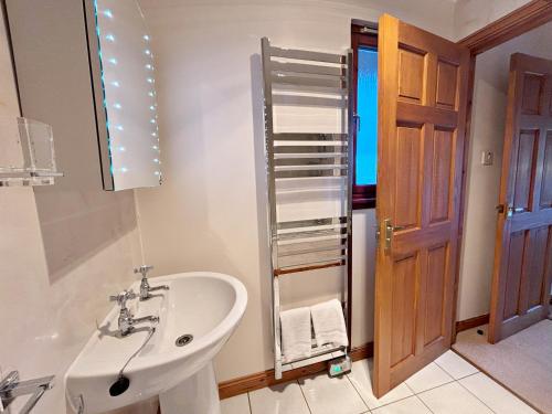 a bathroom with a sink and a toilet and a mirror at Fisher chalet in Crianlarich