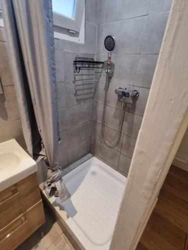 une salle de bain avec une douche avec un rideau de douche dans l'établissement Beau duplex sur le vieux port, à Marseille
