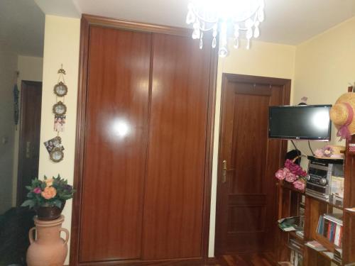um quarto com uma porta de madeira e uma televisão em PITO DÓ INVERNO. em Vigo