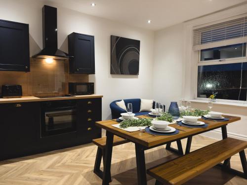 a kitchen and living room with a wooden table at Station House Haworth in Haworth