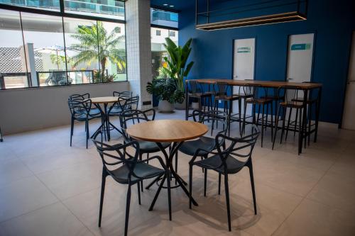 a row of tables and chairs in a room with blue walls at Apart Hotel Porto Príncipe in Cabo Frio