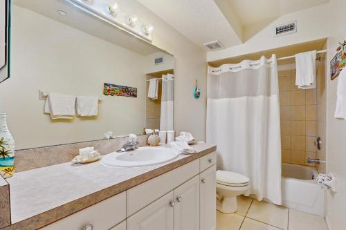 a bathroom with a sink and a toilet and a shower at Captain's Cove 304 in Clearwater Beach