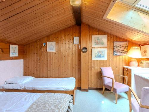 a bedroom with two beds and a chair at Appartement Morzine, 5 pièces, 8 personnes - FR-1-754-63 in Morzine