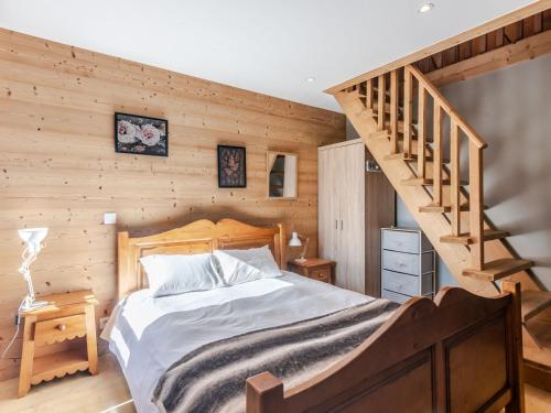 - une chambre avec un lit et un mur en bois dans l'établissement Superbe Duplex T5 Rénové, 10 Pers, Garage, à 2 Pas du Centre de Morzine - FR-1-754-29, à Morzine
