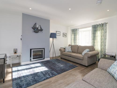 a living room with a couch and a fireplace at Beach Cottage in Redruth