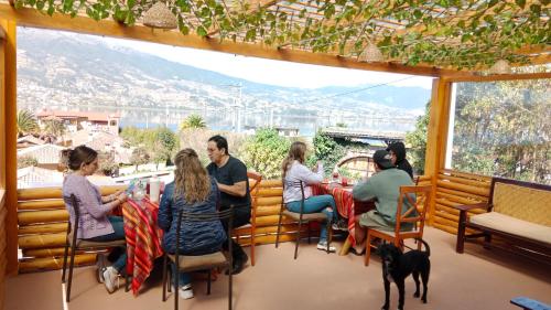 a group of people sitting at a restaurant with a dog at Bellavista Casa de Huéspedes in San Pablo
