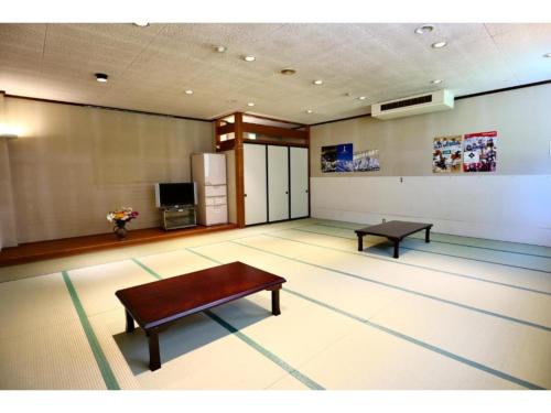 um quarto com uma mesa e um banco no chão em Hakuba park hotel - Vacation STAY 96005v em Hakuba