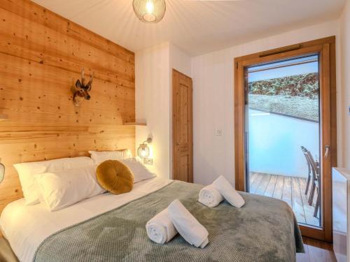 - une chambre avec un lit et un mur en bois dans l'établissement Bel appart 3* refait à neuf au pied des pistes, centre Morzine, 4 pers, terrasse, wifi, garage - FR-1-754-58, à Morzine