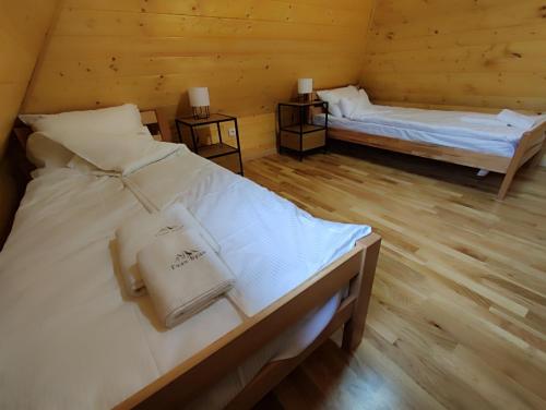 a room with two beds in a log cabin at Brvnare Golo Brdo in Mokra Gora