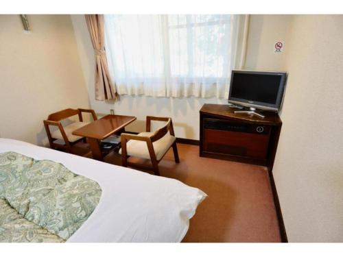 um quarto de hotel com uma cama e uma televisão numa cómoda em Hakuba park hotel - Vacation STAY 95996v em Hakuba