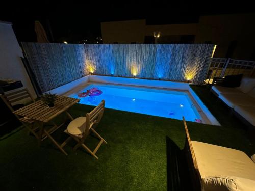 een klein zwembad met 2 stoelen en een tafel bij Chateau Gabriel Luxury 6 BR Villa with Heated Pool in Bet Shemesh