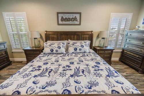 a bedroom with a bed with a blue and white comforter at Spacious Home With Heated Pool! Sleeps 15! Billiard table! in Hernando Beach