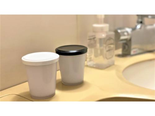 two cups sitting on a bathroom counter next to a sink at Hotel Area One Oita - Vacation STAY 99740v in Oita
