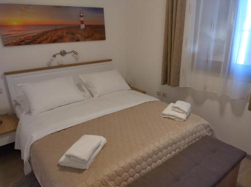a bedroom with a bed with two towels on it at Apartmani Bernarda in Poreč