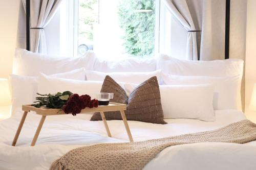 - un lit avec des oreillers blancs et une table fleurie dans l'établissement Fully Equipped Cosy Flat Close to Malmö&Copenhagen, à Vellinge