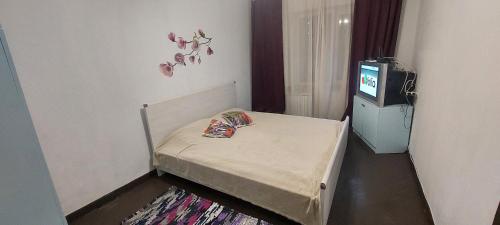 キーウにあるКвартира по вул Ніженська 29гのテレビ付きの客室の小さなベッド1台分です。