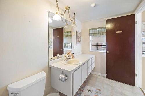 a bathroom with a sink and a toilet and a mirror at Waterfront home with pool and gameroom! in Hernando Beach
