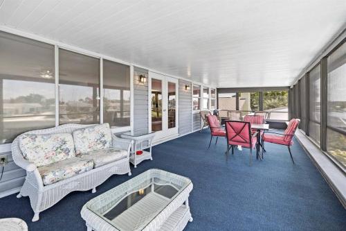 a porch with a couch and a table and chairs at Waterfront home with pool and gameroom! in Hernando Beach